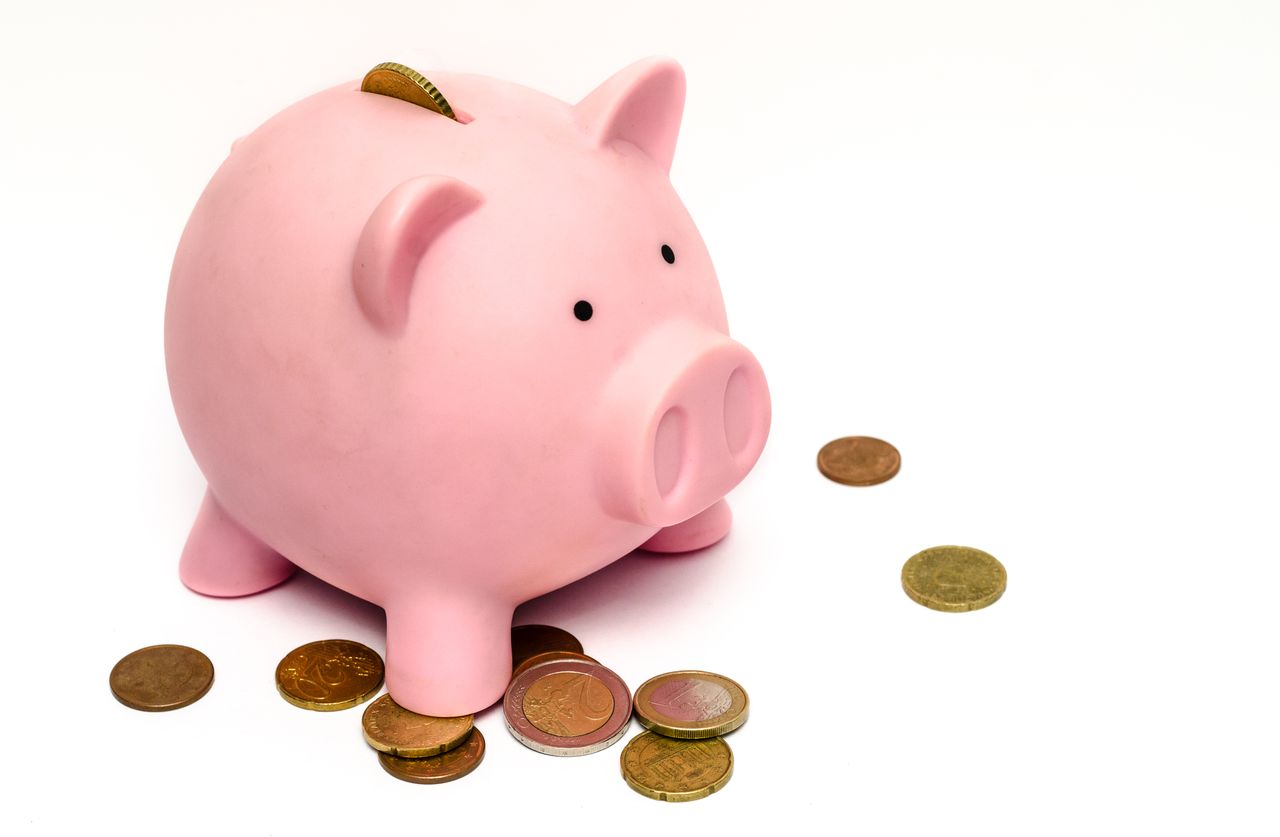 Piggy bank surrounded by coins, employer contributions adding to retirement savings