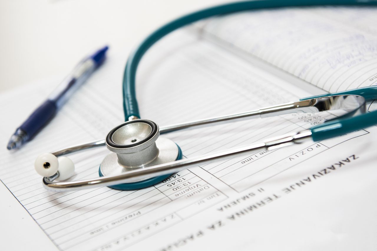Stethoscope resting on a medical report, the paperwork side of health insurance