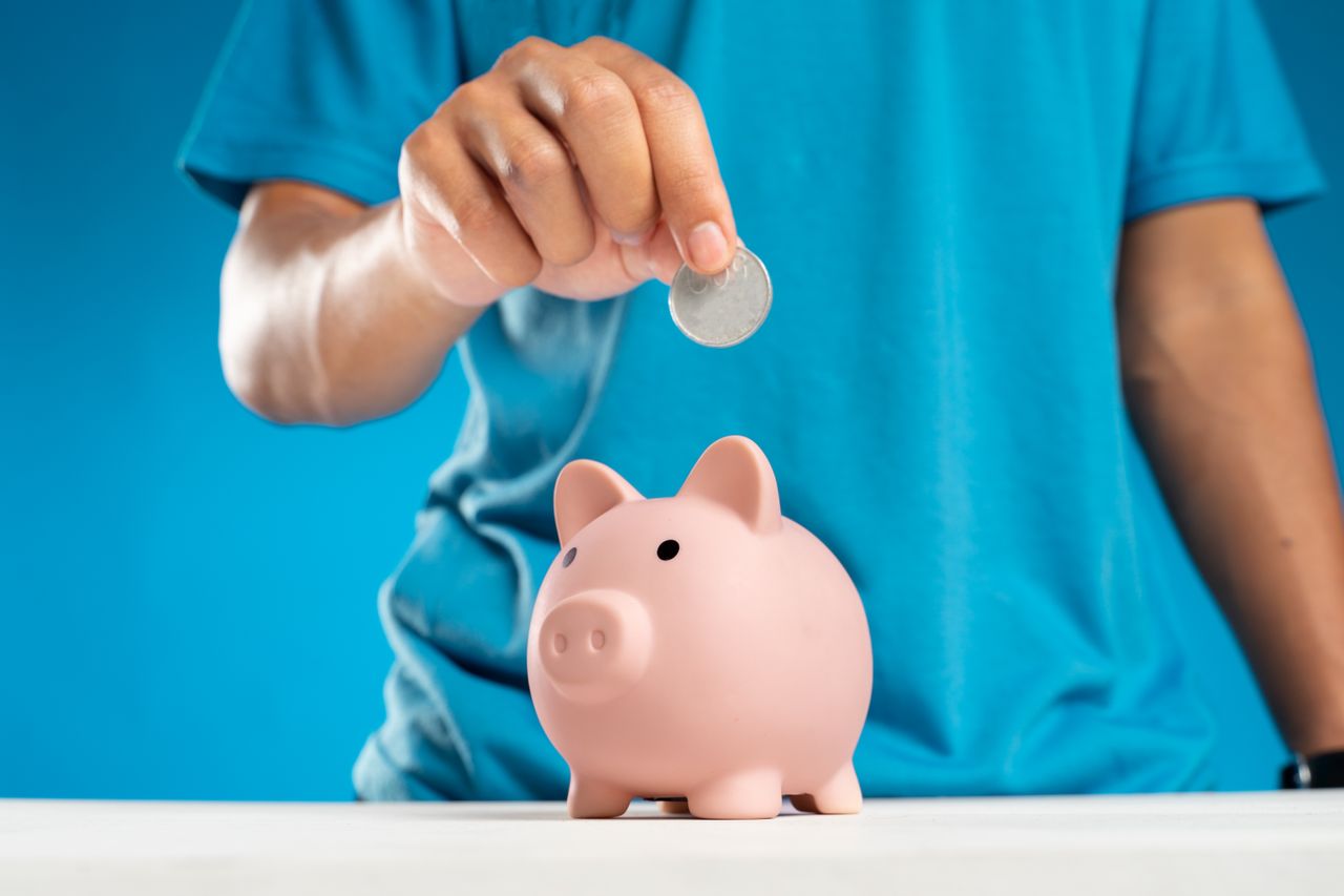 Coin dropping into a piggy bank, steady contributions filling a retirement account