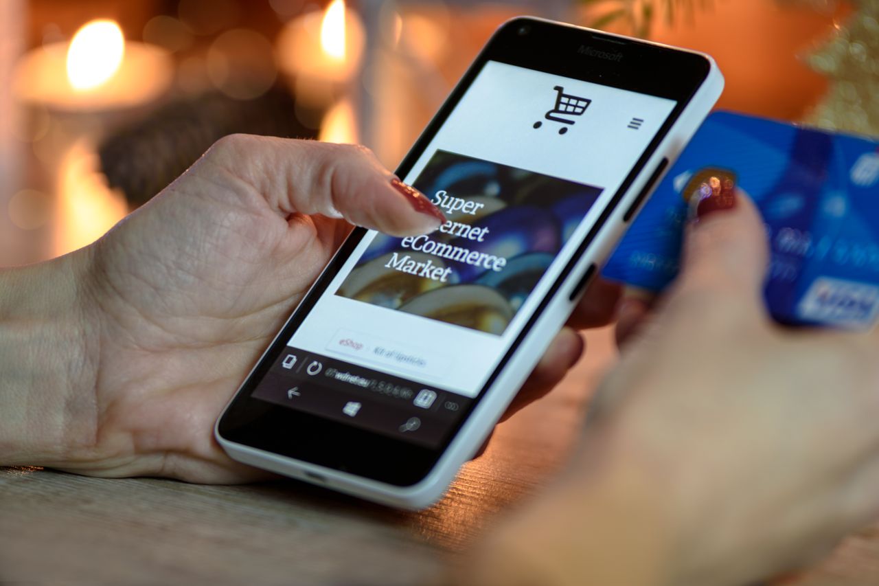 Person setting up a new bank account on a smartphone with their card in hand
