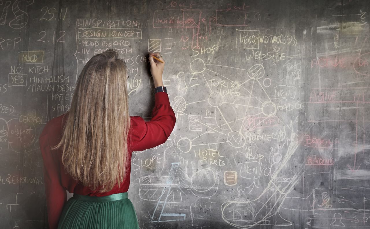 A person studying money concepts with a notebook and calculator, representing financial literacy