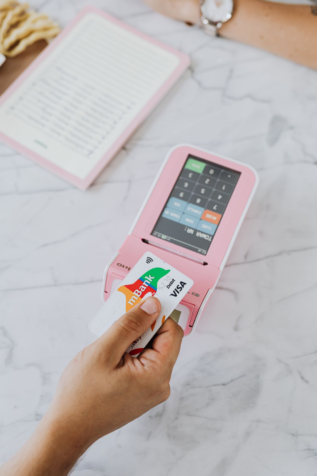 Person paying with a bank card, representing everyday use of a well-chosen bank account