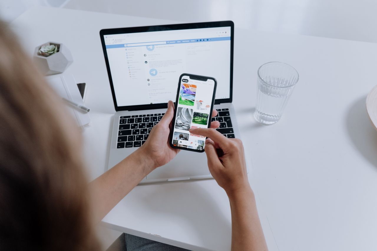 Freelancer managing money on a laptop and phone, smoothing an irregular income