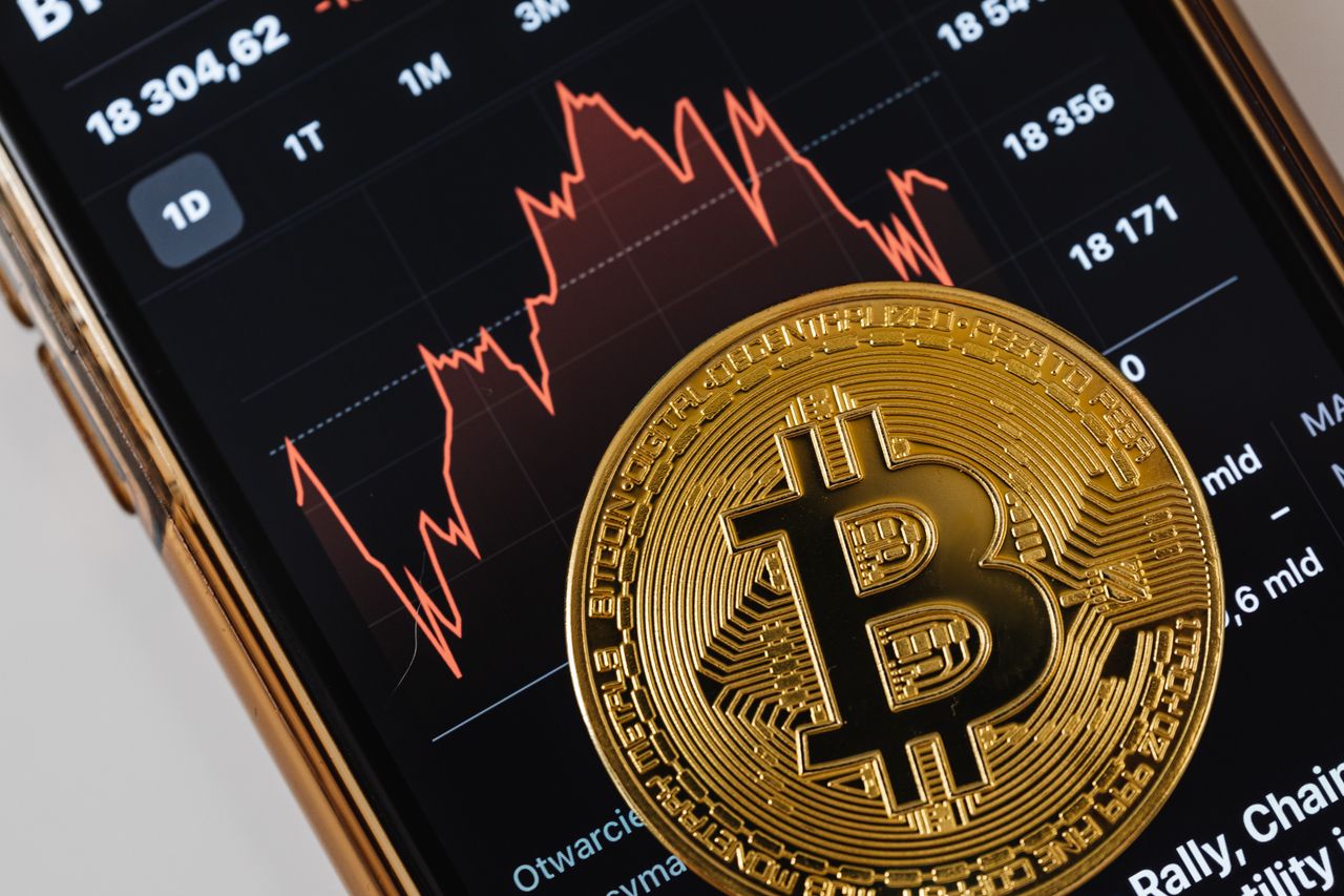 A Bitcoin coin resting on tax forms and a calculator, representing crypto taxation