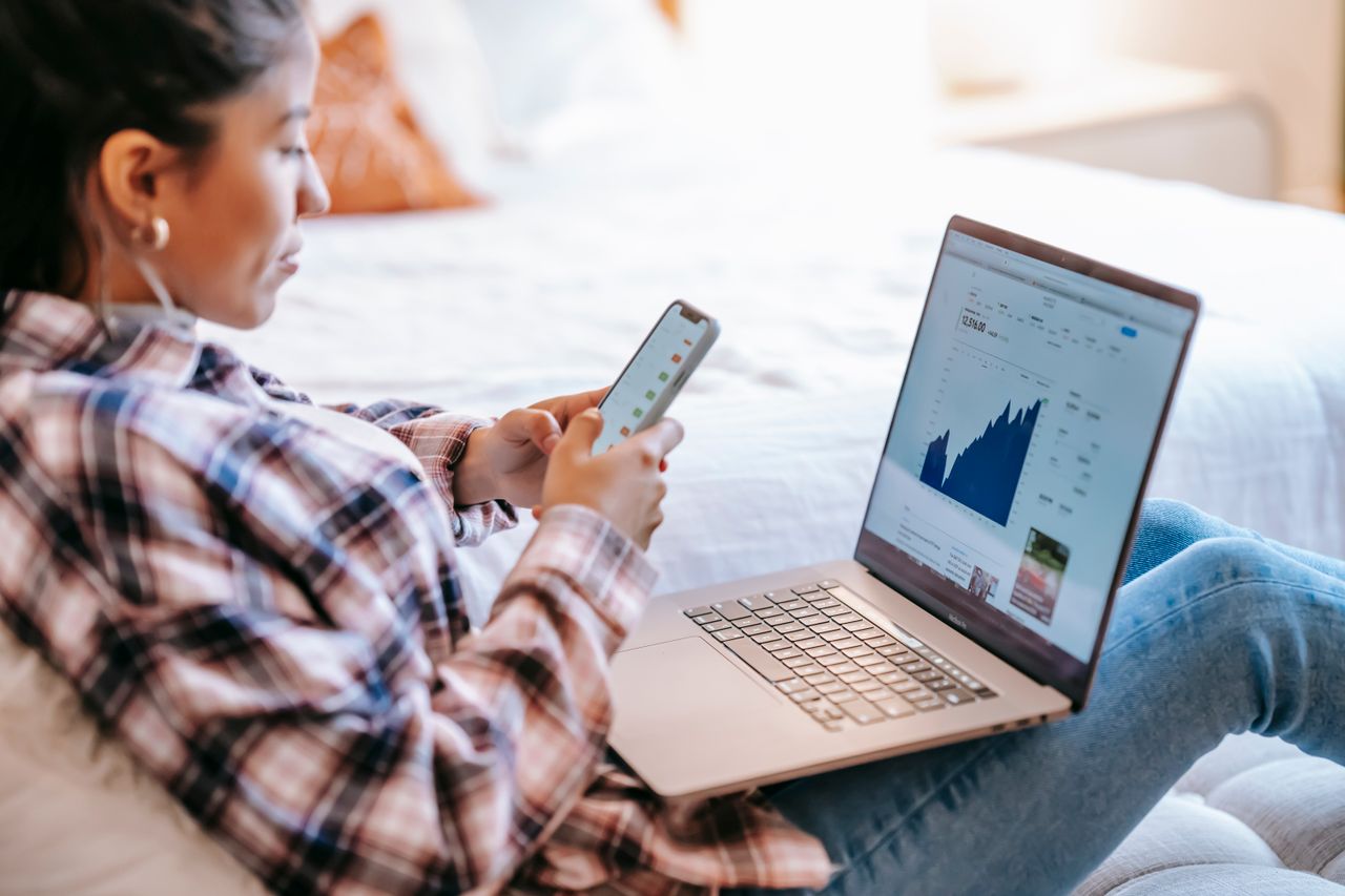 Person using a banking app to manage a checking account at a desk
