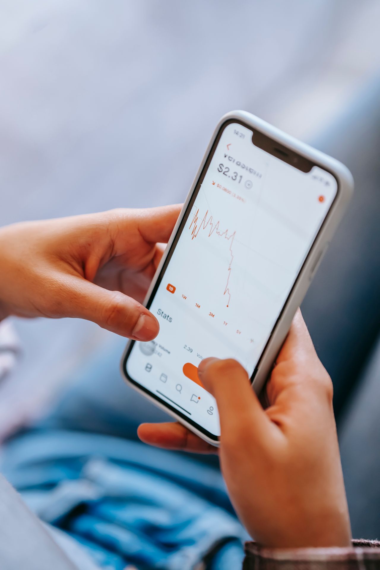 Hands holding a smartphone showing stock market data, learning the basics