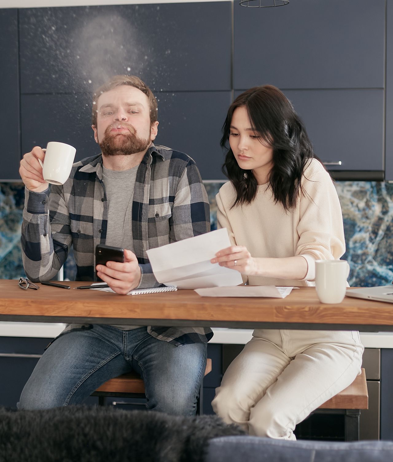Couple reviewing bills at the kitchen table, taking honest stock of their debts