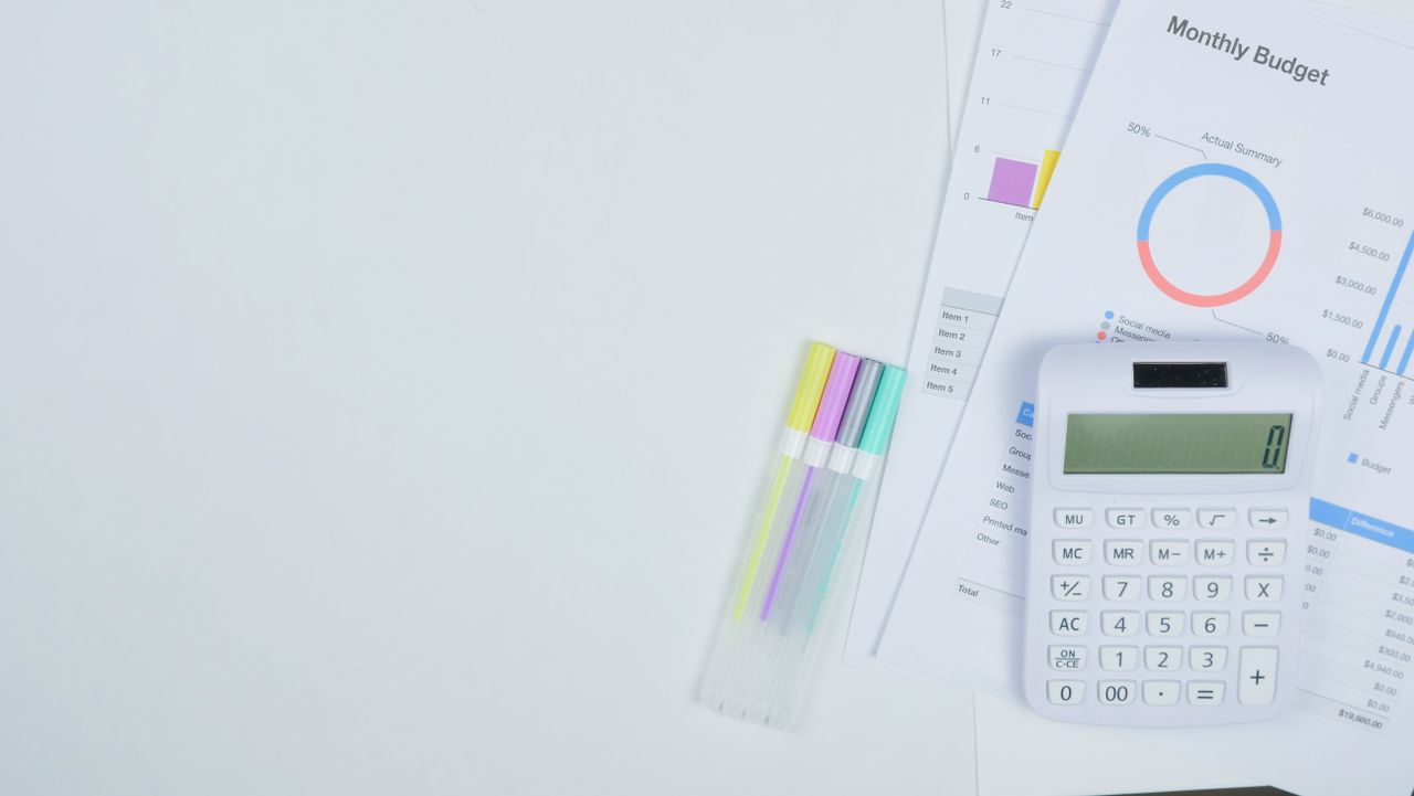 Budget planning documents with a calculator and pens on a desk