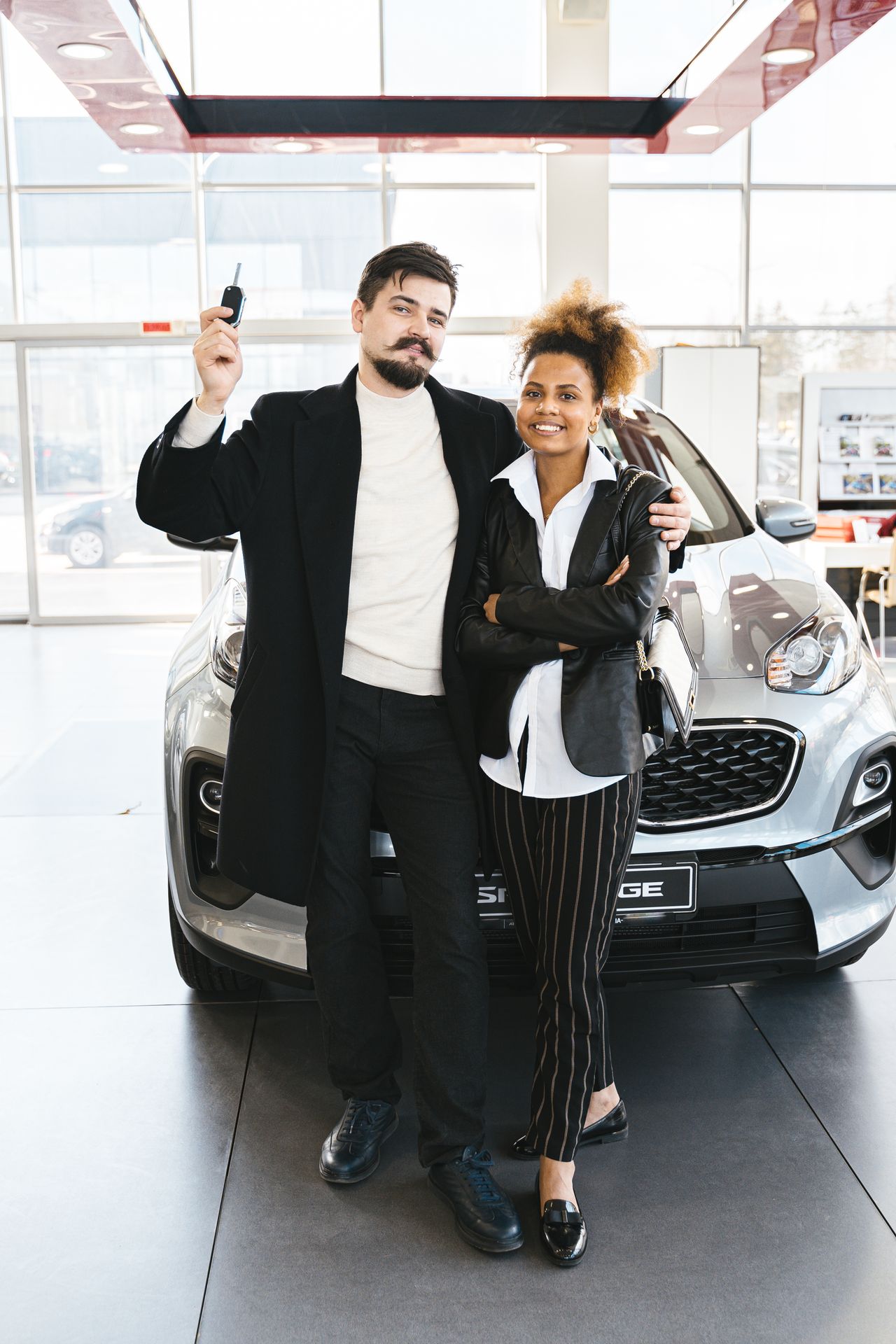 Buyer receiving car keys at a dealership after arranging an auto loan