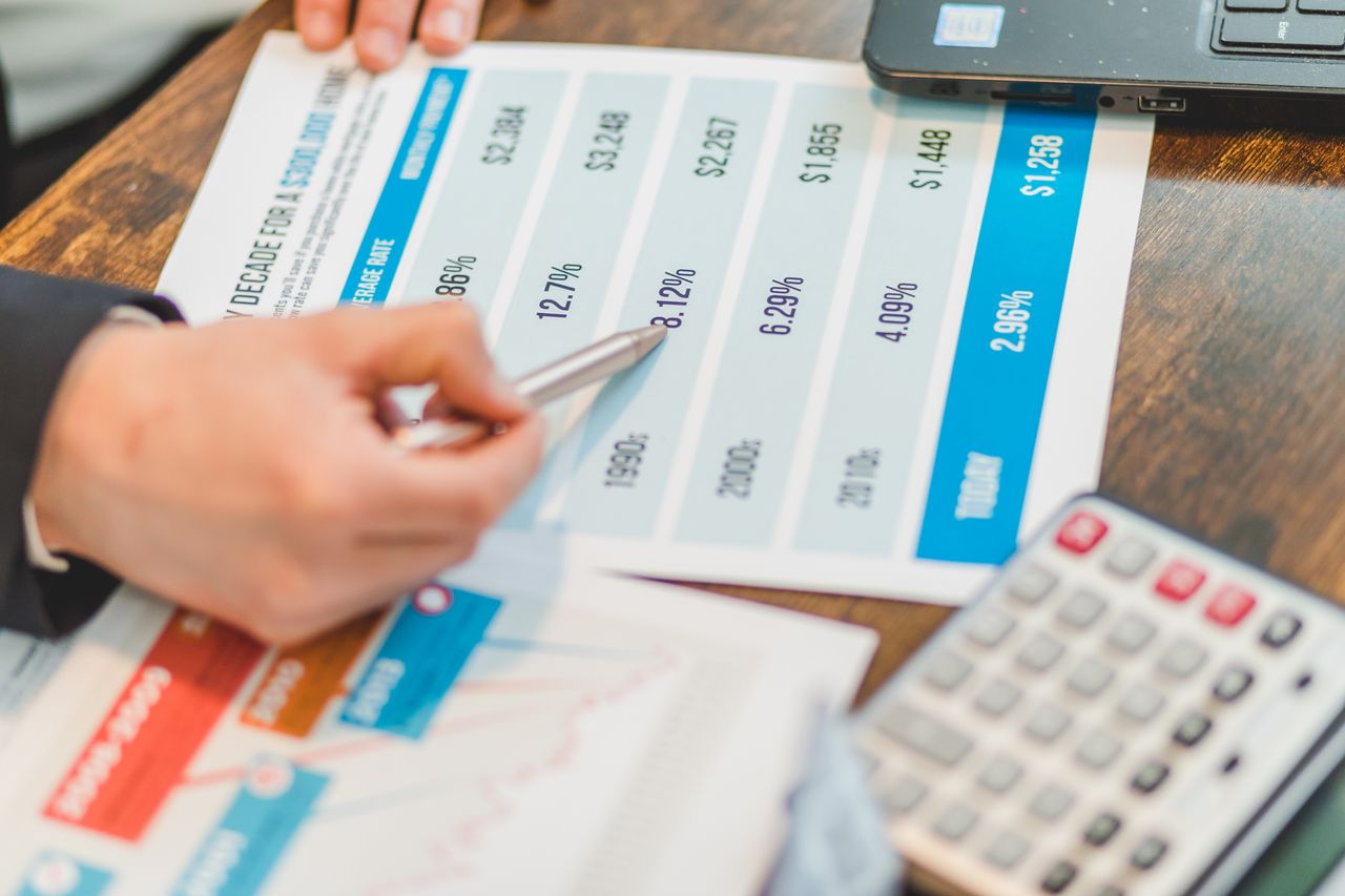 A person signing home purchase documents with house keys on the table, representing mortgage closing