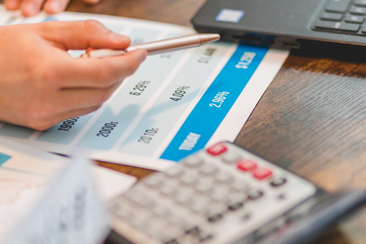 Homebuyer signing mortgage application paperwork with a lender at a desk