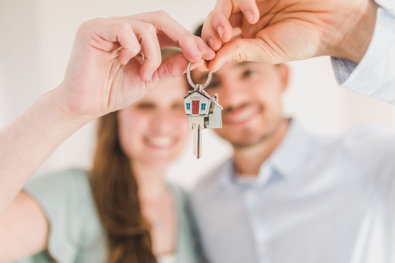 Couple holding the key to their first home