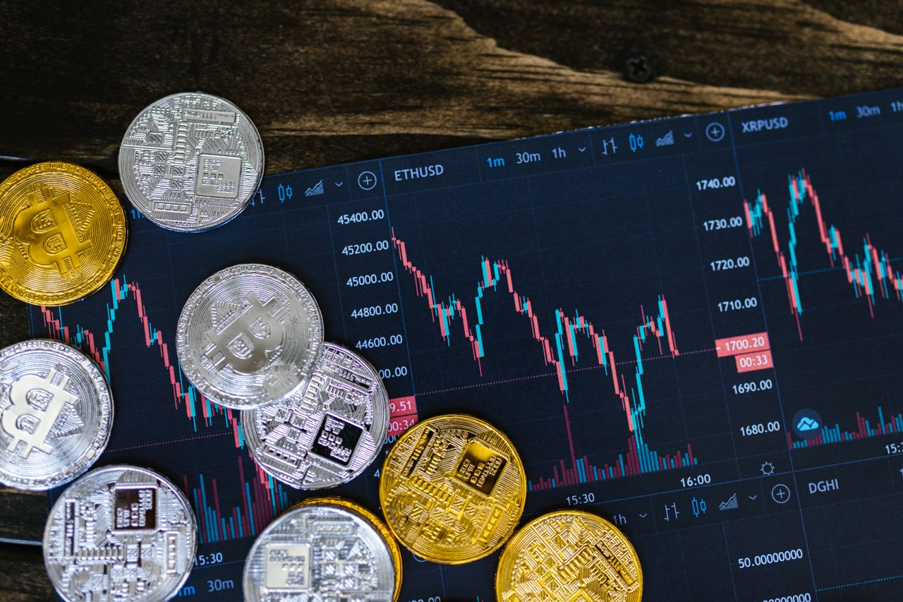 Stacked crypto coins with a growth chart, representing staking rewards and yield