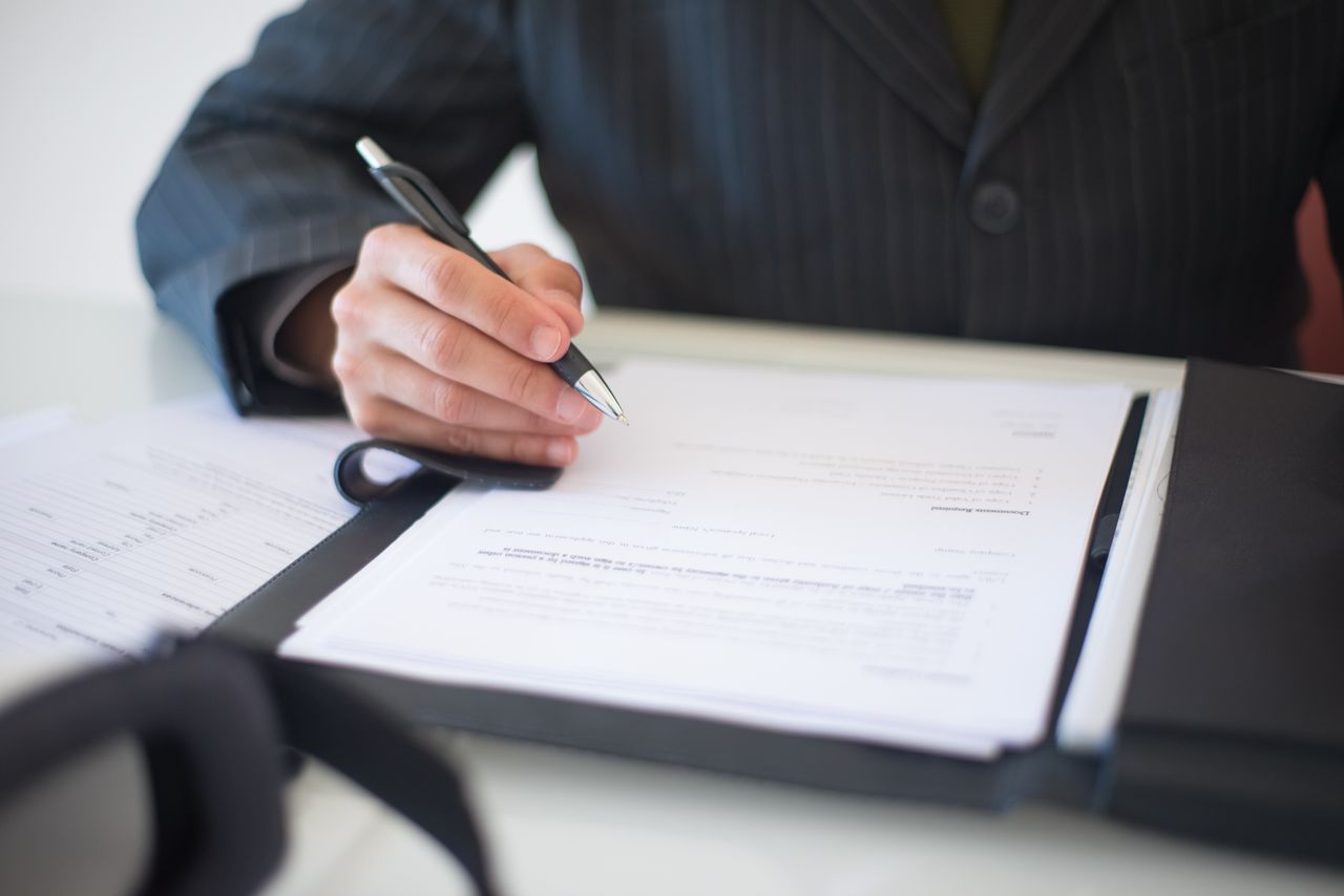 Signing an insurance policy after checking limits, deductibles, and exclusions