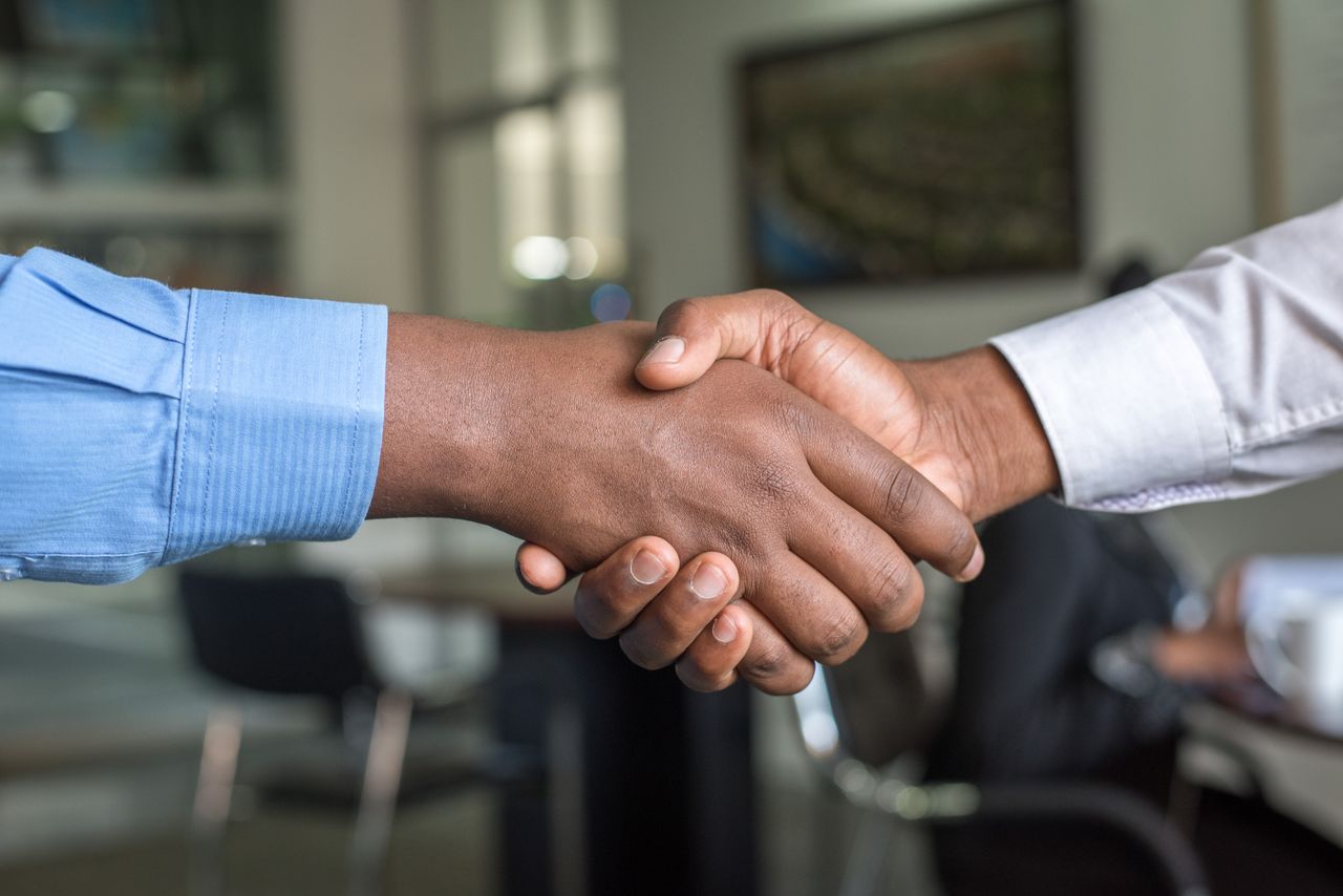 Two people reviewing and signing a loan agreement together at a table