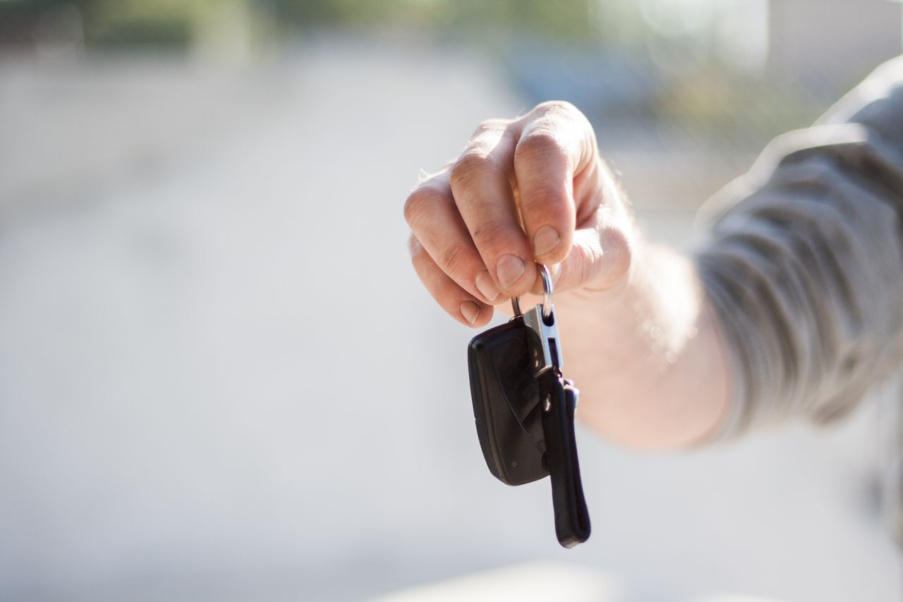 A car key and loan paperwork on a dealership desk, representing a car loan