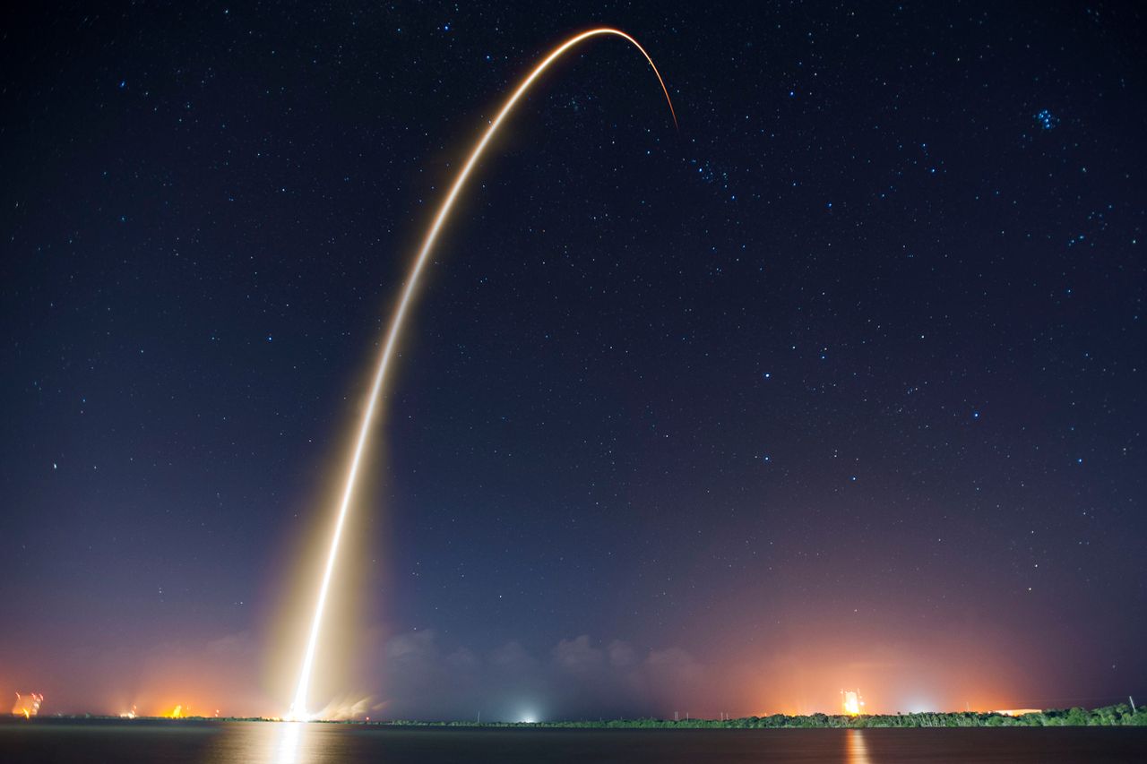 A rocket launching into the sky, representing commercial space investment